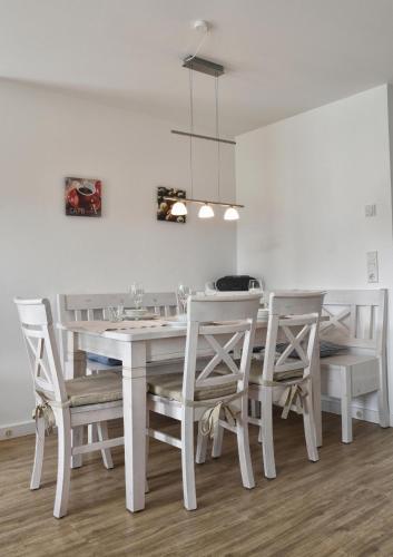 a white dining room with a white table and chairs at Stadtwohnung 8 in Wyk auf Föhr