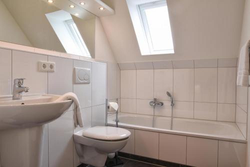 W łazience znajduje się umywalka, toaleta i wanna. w obiekcie Stadtwohnung 8 w mieście Wyk auf Föhr