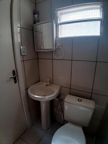 a small bathroom with a toilet and a sink at Casa na praia da Pinheira in Palhoça