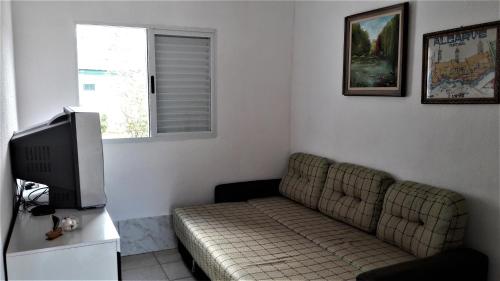 a living room with a couch and a television at Casa na praia da Pinheira in Palhoça