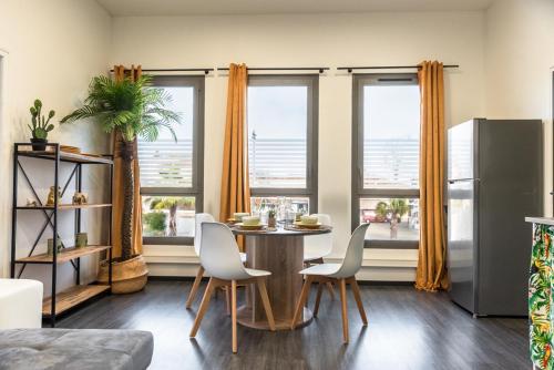 une salle à manger avec une table, des chaises et des fenêtres dans l'établissement FRENCHY HOME- PLACE de la CLAIRE- BASSIN d'ARCACHON, à Gujan-Mestras