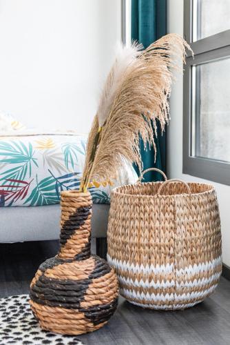 deux paniers posés sur le sol à côté d'un canapé dans l'établissement FRENCHY HOME- PLACE de la CLAIRE- BASSIN d'ARCACHON, à Gujan-Mestras