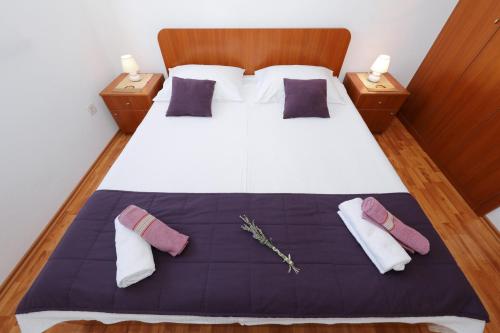 a bedroom with a large bed with two pillows at Apartments Suzana in Ždrelac