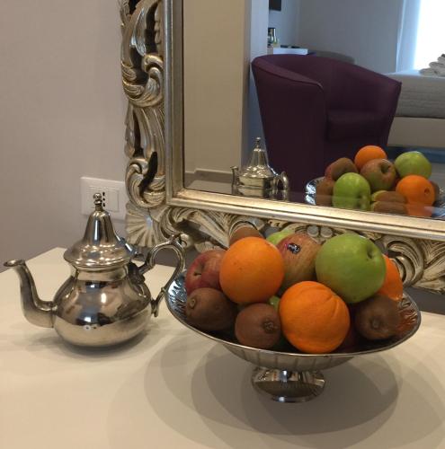 a bowl of fruit on a table in front of a mirror at ROYAL GARDENS in Caserta