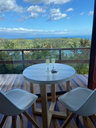 a table with two glasses of wine on a balcony at Cabañas Tungulú in Puerto Montt
