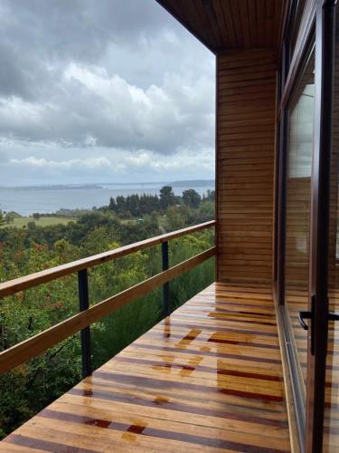 a balcony of a house with a view of the ocean at Cabañas Tungulú in Puerto Montt