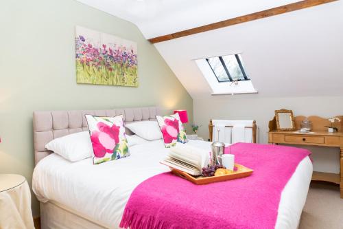 a bedroom with a large white bed with a pink blanket at Stoney Moat in Shrewsbury