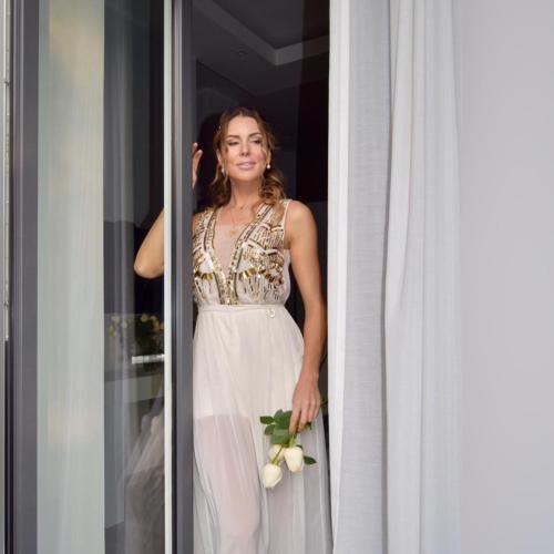 a woman in a white dress holding a flower at ROYAL GARDENS in Caserta