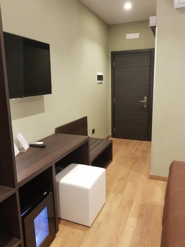 a room with a desk with a television and a white stool at Hotel Europa Art Caserta in Caserta