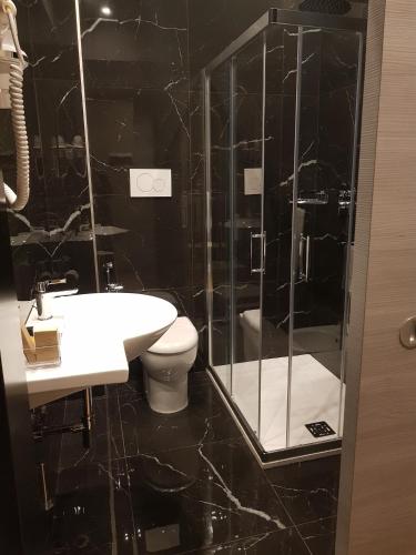 a bathroom with a toilet and a glass shower at Hotel Europa Art Caserta in Caserta