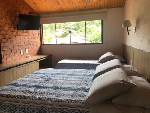 um quarto com uma cama com almofadas e uma janela em Casa de São Jorge em Pirenópolis