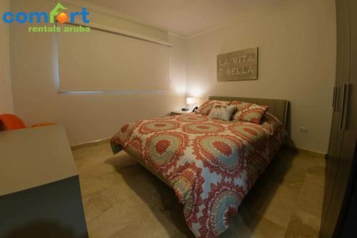 パーム・イーグル・ビーチにある112: 1-Bedroom Grd floor condo w/patio. Palm Beachのベッドとランプ付きのテーブルがある寝室