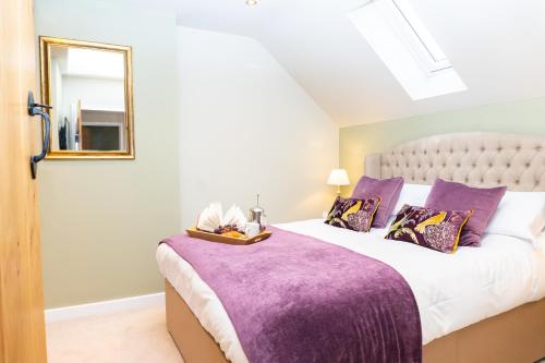 a bedroom with a large bed with a purple blanket at The Patches in Shrewsbury
