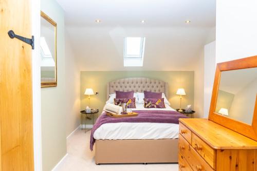 a bedroom with a large bed with purple pillows at The Patches in Shrewsbury