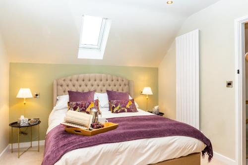 a bedroom with a bed with purple sheets and a window at The Patches in Shrewsbury