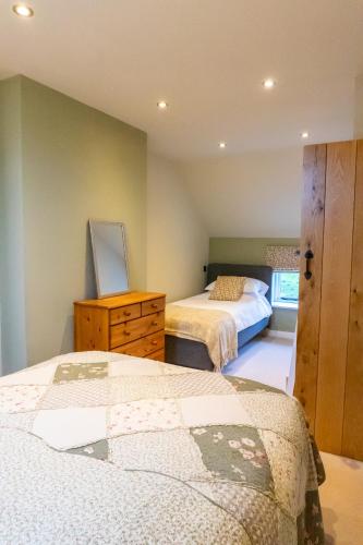 a bedroom with two beds and a dresser in it at The Patches in Shrewsbury