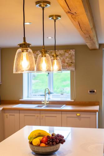a bowl of fruit on a kitchen counter with lights at The Patches in Shrewsbury