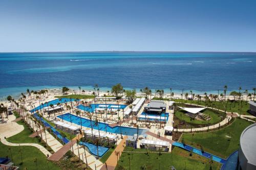 an aerial view of a resort with a pool and the ocean at Riu Palace Peninsula - All Inclusive in Cancún