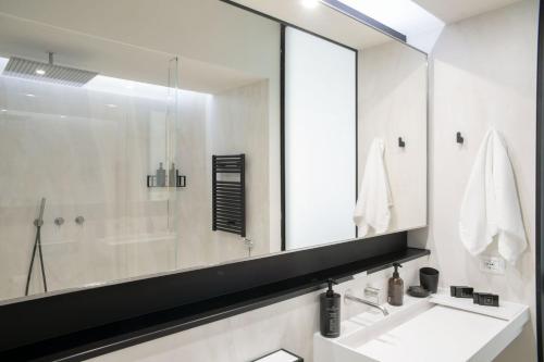 a bathroom with a sink and a large mirror at BMORE Duomo - Luxury Apartments near Duomo in Milan