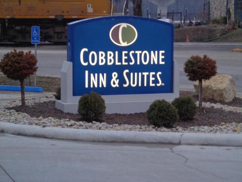 a blue sign for a colgateitution inn and suites at Cobblestone Inn & Suites - Marquette in Marquette