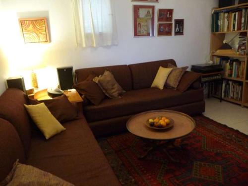 uma sala de estar com um sofá e uma mesa em The Artist's House Overlooking the Bay of Haifa em Haifa