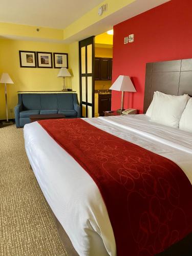 a hotel room with a large bed and a couch at Comfort Suites Rock Hill Manchester Meadows Area in Rock Hill