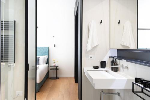 a bathroom with a white sink and a mirror at BMORE Duomo - Luxury Apartments near Duomo in Milan