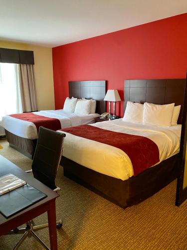 two beds in a hotel room with red walls at Comfort Suites Rock Hill Manchester Meadows Area in Rock Hill