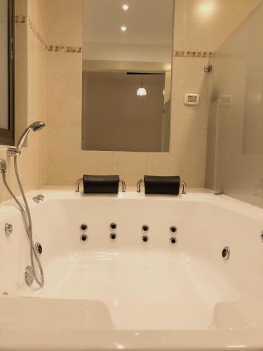 a white bath tub in a bathroom with a mirror at Kinneret View in Kinneret