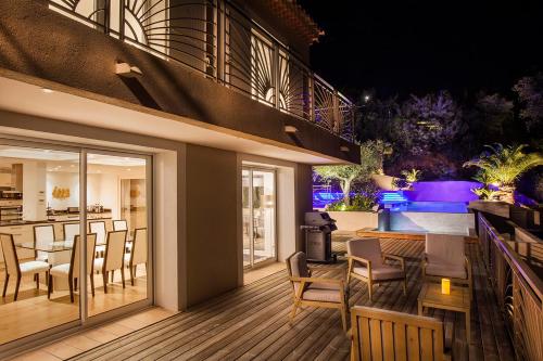 un patio avec une table et des chaises sur une terrasse dans l'établissement Prestigious sea view villa, à La Garonnette-Plage