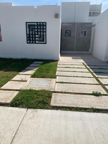 einen Gehweg vor einem weißen Gebäude in der Unterkunft Hogar Cálido y Acogedor in León
