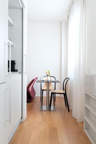 a dining room with a glass table and chairs at BMORE Duomo - Luxury Apartments near Duomo in Milan
