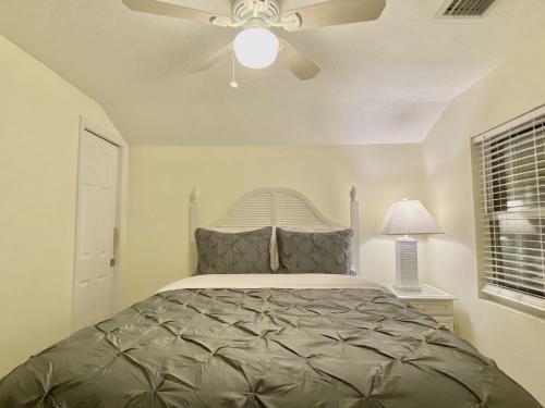 a bedroom with a bed with a ceiling fan at Siesta Beach Cottage, Sleeps 6, Walk to Beach, Stores, & Restaurants in Siesta Key