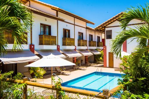 un hôtel avec une piscine et des parasols dans l'établissement Apart Hotel Forte Blu, à Praia do Forte