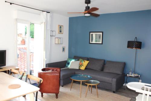 un salon avec un canapé et un mur bleu dans l'établissement Arca Noae, à Sète
