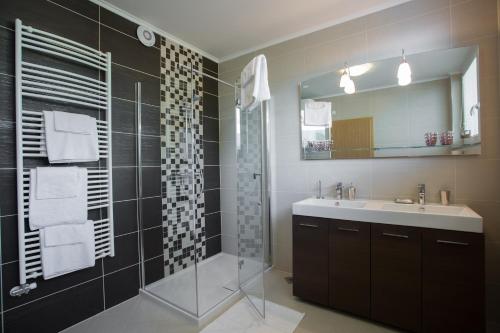 y baño con lavabo y ducha con espejo. en Apartments Benedičič en Bled