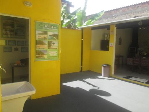 a yellow bathroom with a sink and a toilet at Suítes Cantinho do Sossego Ubatuba in Ubatuba