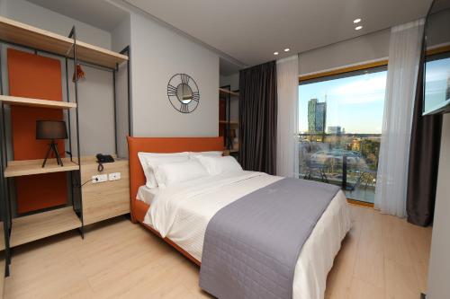 a bedroom with a large bed and a large window at Mulaj Hotel in Tirana