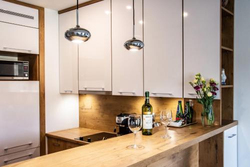 a kitchen with white cabinets and wine glasses on a counter at ApArt Bulwary Wrocław in Wrocław