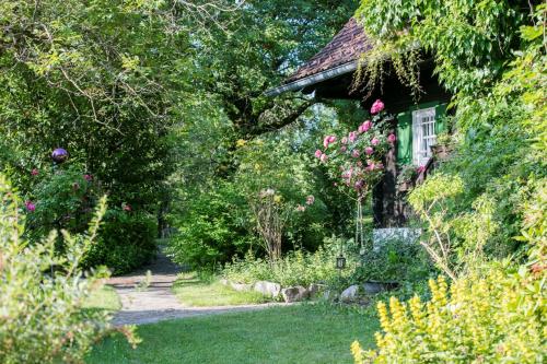 a garden in front of a house with flowers at Altes Gehöft am Lormanberg in Kirchberg an der Raab