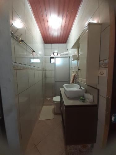 a bathroom with a sink and a toilet at Casinha do Trapiche in Penha