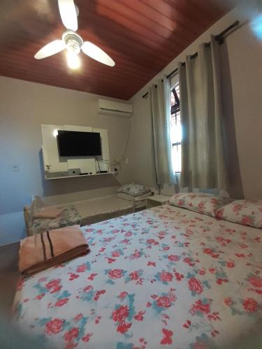 1 dormitorio con 1 cama grande y TV en Casinha do Trapiche, en Penha