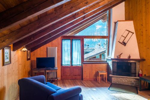 a living room with a large window and a fireplace at Mont Blanc Apartments in Morgex
