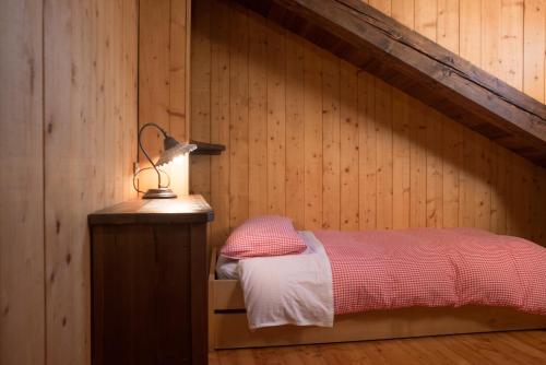 a bedroom with a bed in a wooden wall at Mont Blanc Apartments in Morgex