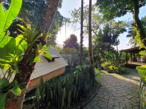 a garden with a building and trees and a path at Pousada e Hostel Holandês in Abraão
