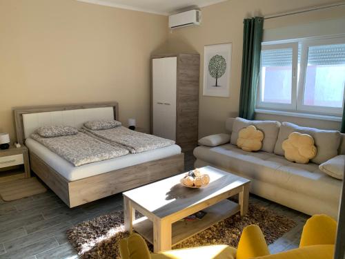 a bedroom with a bed and a couch at Apartman Hana in Sombor