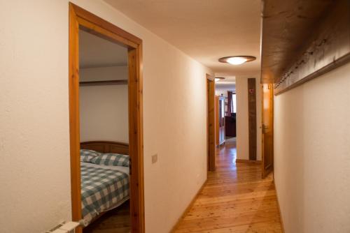 a hallway leading to a bedroom with a bed at Mont Blanc Apartments in Morgex