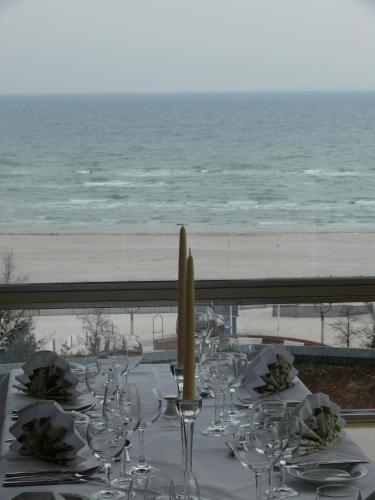 a table with wine glasses and a view of the beach at Hotel Zur schönen Aussicht in Grömitz