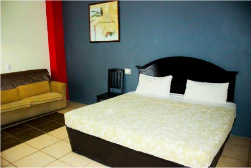 a bedroom with a large bed and a couch at Hotel Pacific in Tecomán