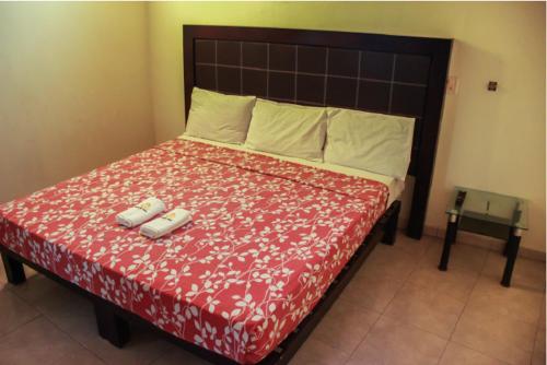 特科曼的住宿－Hotel Pacific，一间卧室配有一张大床和红色的床罩
